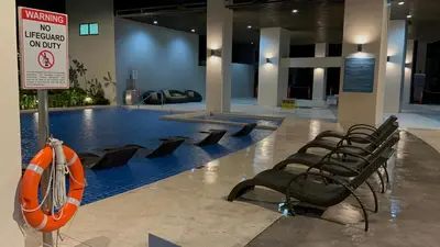 a swimming pool with a row of chairs in a building at S Residences Luxury Unit in Manila