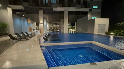 a swimming pool in a building with chairs around it at S Residences Luxury Unit in Manila