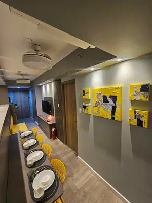 a room with a row of tables and yellow chairs at S Residences Luxury Unit in Manila