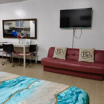 a living room with a red couch and a table at LDN Secret Crib - Newport City in Manila