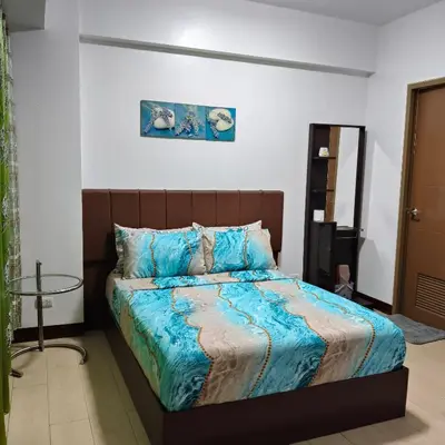 a bedroom with a bed with a blue comforter at LDN Secret Crib - Newport City in Manila