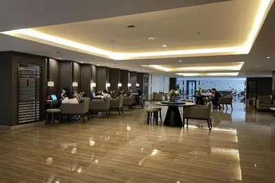 a lobby with people sitting at tables in a restaurant at FCMCO Condotel in Manila