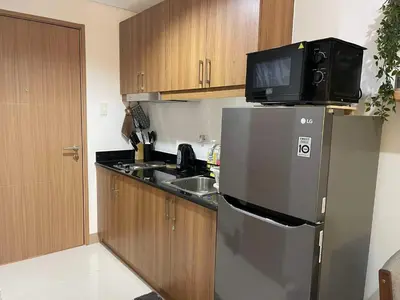 a kitchen with a refrigerator and a tv on top of it at Lush Residences Makati City by darpm in Manila