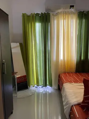 a bedroom with green and yellow curtains and a bed at Lush Residences Makati City by darpm in Manila