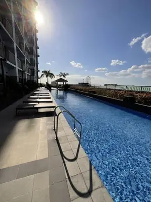 a large swimming pool next to a building at Sky PortLuxe Studio Near MOA in Manila