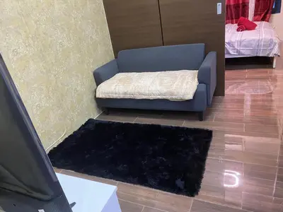 a living room with a blue couch and a rug at Penthouse Fantasy in Manila