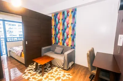 a room with a chair and a bed and a table at Penthouse Fantasy in Manila