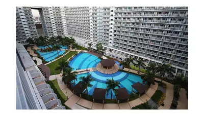 an overhead view of a swimming pool in front of a large building at Shell Residences Staycation near SM MOA in Manila