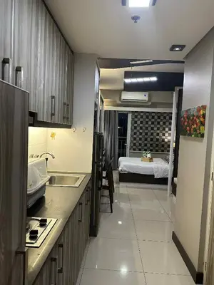 a kitchen with a sink and a room with a bed at Shell Residences Staycation near SM MOA in Manila