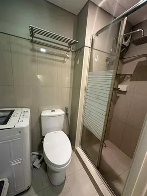 a small bathroom with a toilet and a shower at Shell Residences Staycation near SM MOA in Manila