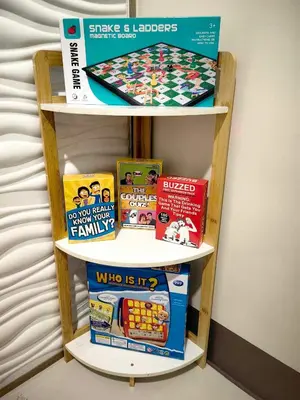 a book shelf with books and games on it at Casa Fama - Fame Residences Staycation in Manila