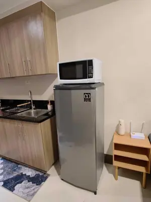 a microwave on top of a refrigerator in a kitchen at Casa Fama - Fame Residences Staycation in Manila