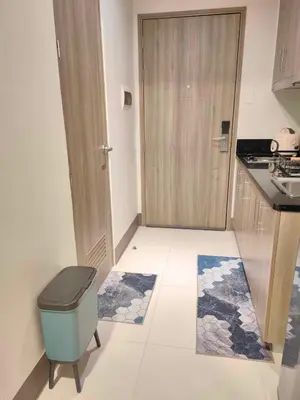 a small kitchen with a door and a trash can at Casa Fama - Fame Residences Staycation in Manila