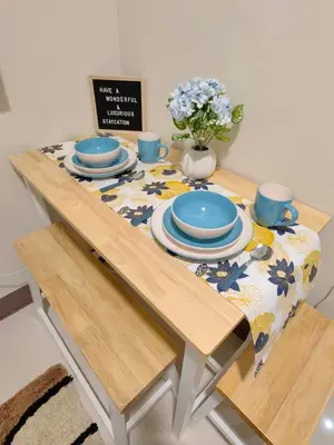 a table with blue dishes and a vase of flowers on it at Casa Fama - Fame Residences Staycation in Manila
