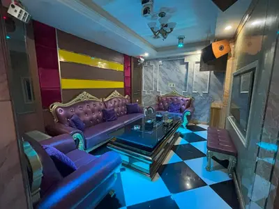 a living room with purple couches and a table at Lido De Paris Hotel in Manila