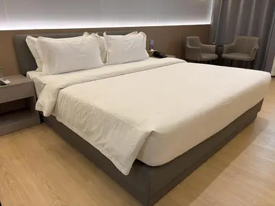 a large bed with white sheets and pillows at Lido De Paris Hotel in Manila