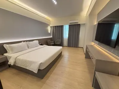 a hotel room with a bed and a flat screen tv at Lido De Paris Hotel in Manila