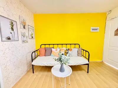 a couch in a room with a yellow wall at Your Comfort Zone Staycation1 in Manila