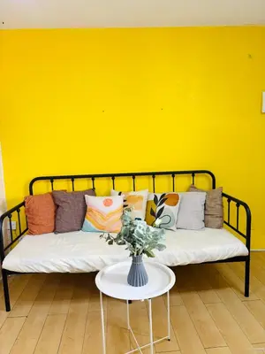 a couch in a room with a yellow wall at Your Comfort Zone Staycation1 in Manila