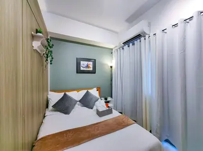 a bedroom with a bed with blue walls at 1BR Condotel with Balcony at FAME Residences #FM11 in Manila