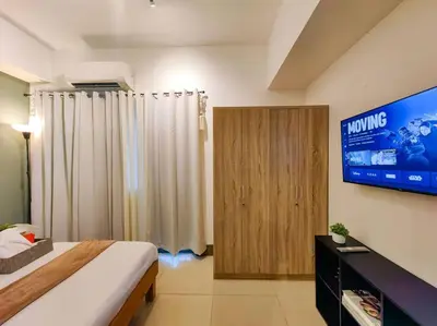 a bedroom with a bed and a television in it at 1BR Condotel with Balcony at FAME Residences #FM11 in Manila