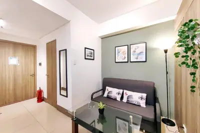 a living room with a couch and a glass table at 1BR Condotel with Balcony at FAME Residences #FM11 in Manila