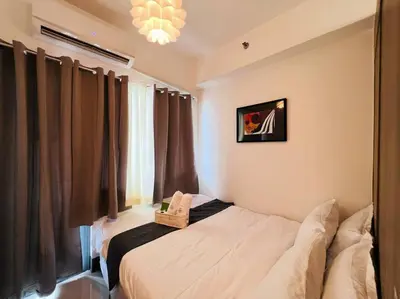 a bedroom with a bed and a window with curtains at 1BR Condotel with Balcony at FAME Residences #FM12 in Manila