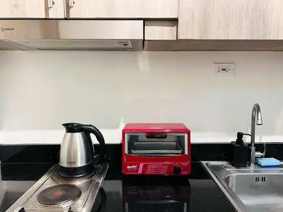a red toaster oven sitting on a kitchen counter at 1BR Condotel with Balcony at FAME Residences #FM12 in Manila