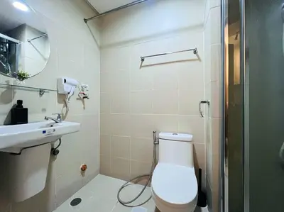 a bathroom with a toilet and a sink and a shower at 1BR Condotel with Balcony at FAME Residences #FM12 in Manila