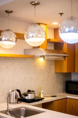 a kitchen with three lights hanging over a sink at Antel Spa & Serenity Suites in Manila