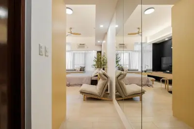 a bedroom with a bed and a living room at Eastwood City Cozy Designer Studio Long Stay Friendly Walk to Mall in Manila