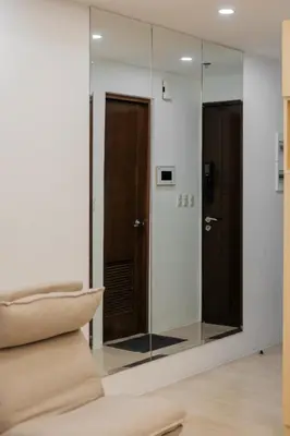 a glass shower in a room with a mirror at Eastwood City Cozy Designer Studio Long Stay Friendly Walk to Mall in Manila