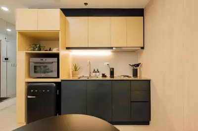 a kitchen with black and white cabinets and a black refrigerator at Eastwood City Cozy Designer Studio Long Stay Friendly Walk to Mall in Manila