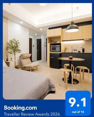 a bedroom with a bed and a table and a kitchen at Eastwood City Cozy Designer Studio Long Stay Friendly Walk to Mall in Manila