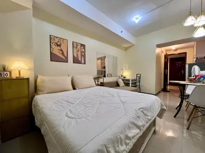 a bedroom with a bed and a dining room at Staycation Condotels for Travellers Near Airport in Manila