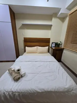 a bedroom with a large bed with towels on it at Staycation Condotels for Travellers Near Airport in Manila