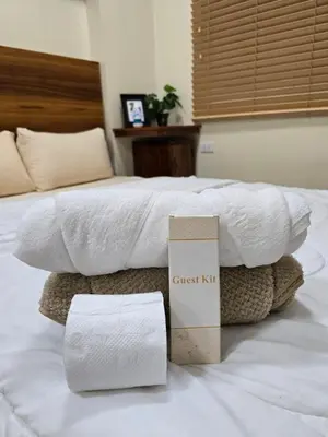 a guest bed with a guest box and towels on it at Staycation Condotels for Travellers Near Airport in Manila