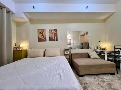 a bedroom with a large bed and a couch at Staycation Condotels for Travellers Near Airport in Manila