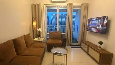 a living room with a couch and a table at South Pad Staycation Sea Residences SM Mall of Asia Tower A, B and E in Manila