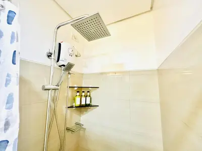 a shower with a shower head in a bathroom at Shore Residences by Premier Suites in Manila