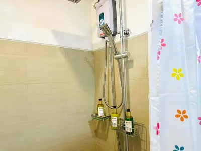 a shower with three bottles of wine in a bathroom at Shore Residences by Premier Suites in Manila