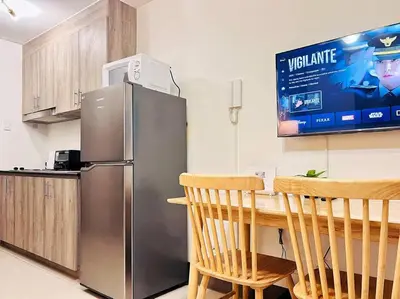a kitchen with a stainless steel refrigerator and a table at 1BR Condotel with Balcony at FAME Residences #FM15 in Manila