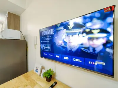 a large flat screen tv hanging on a wall at 1BR Condotel with Balcony at FAME Residences #FM15 in Manila