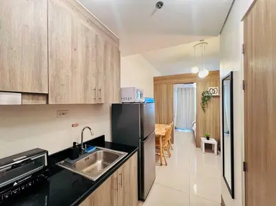 a kitchen with a sink and a black refrigerator at 1BR Condotel with Balcony at FAME Residences #FM15 in Manila