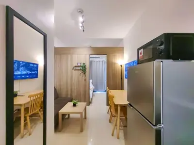 a kitchen and dining room with a refrigerator and a table at 1BR Condotel with Balcony at FAME Residences #FM16 in Manila