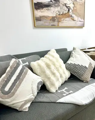 a gray couch with pillows on top of it at Azure Luxury Suite in Manila