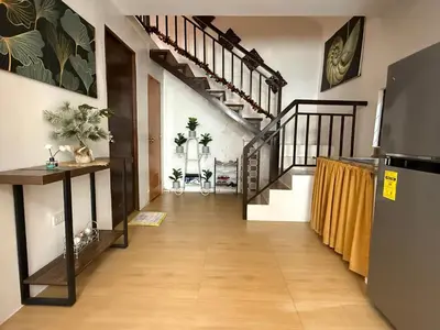 a hallway with wooden floors and stairs in a house at Green Glory Staycation in Amadeo in Cavite