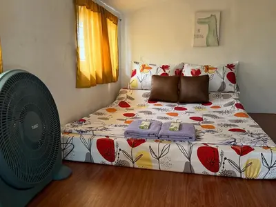a bedroom with a bed and a fan at Green Glory Staycation in Amadeo in Cavite