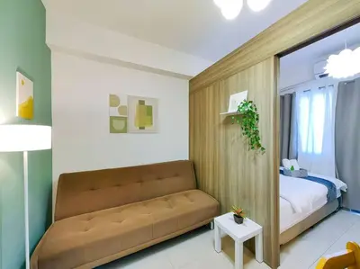 a living room with a couch and a bed at 1BR Condotel with Balcony at FAME Residences #FM18 in Manila