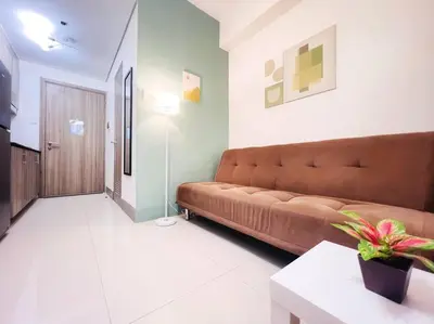 a living room with a brown couch in a room at 1BR Condotel with Balcony at FAME Residences #FM18 in Manila